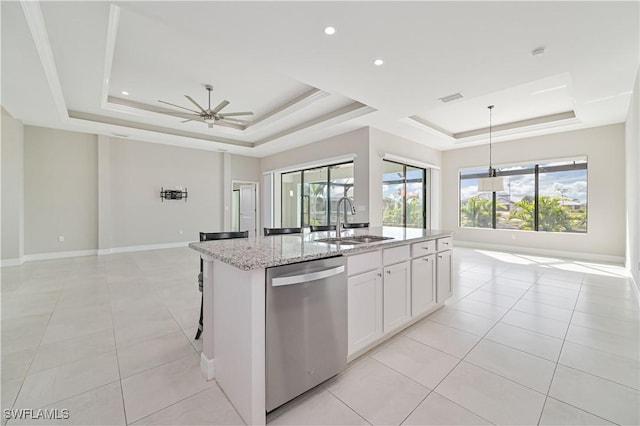 kitchen with sink, white cabinetry, a tray ceiling, dishwasher, and a kitchen island with sink