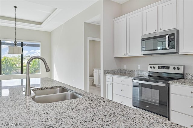 kitchen with white cabinetry, appliances with stainless steel finishes, sink, and light stone counters