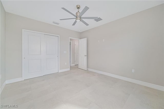 unfurnished bedroom with ceiling fan and a closet