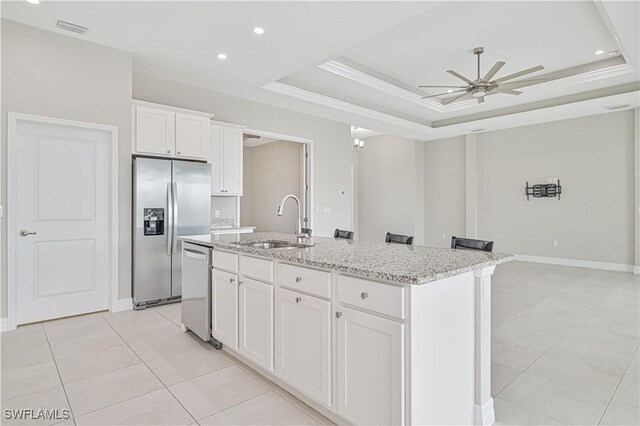 kitchen with white cabinetry, sink, stainless steel appliances, and a center island with sink