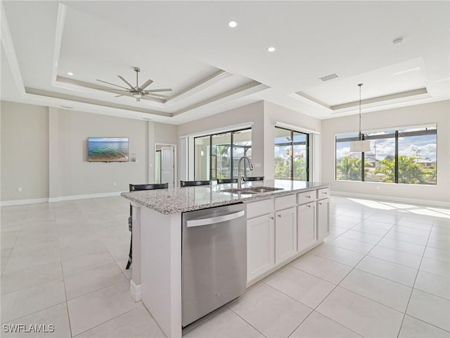 kitchen featuring sink, a kitchen island with sink, white cabinets, stainless steel dishwasher, and a raised ceiling