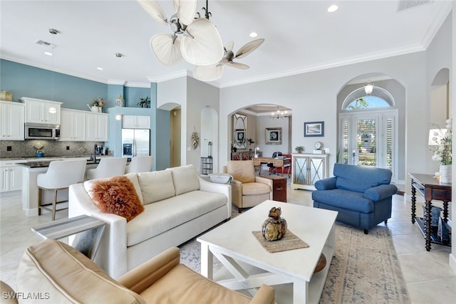 living room with light tile patterned flooring, a towering ceiling, and ornamental molding