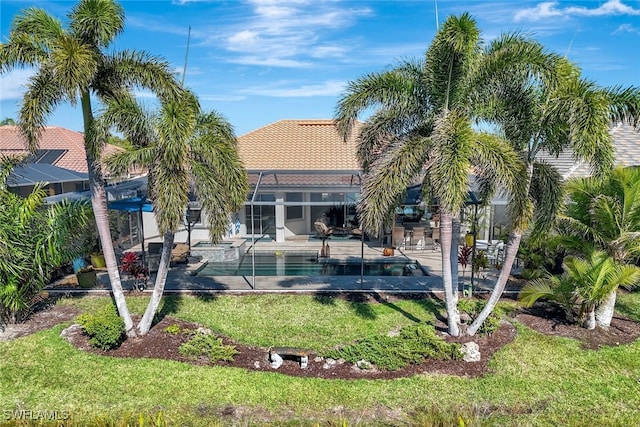 back of house featuring a patio, a yard, and glass enclosure