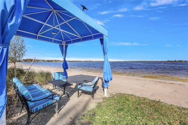 view of patio with a water view, a view of the beach, and a gazebo