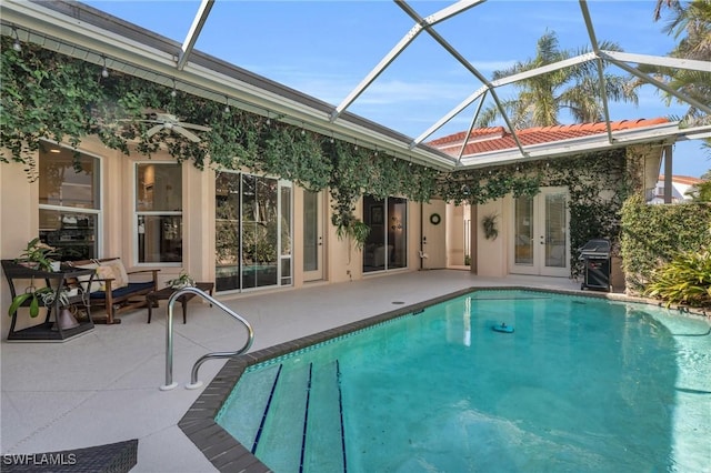 view of swimming pool with a patio area, grilling area, french doors, and glass enclosure