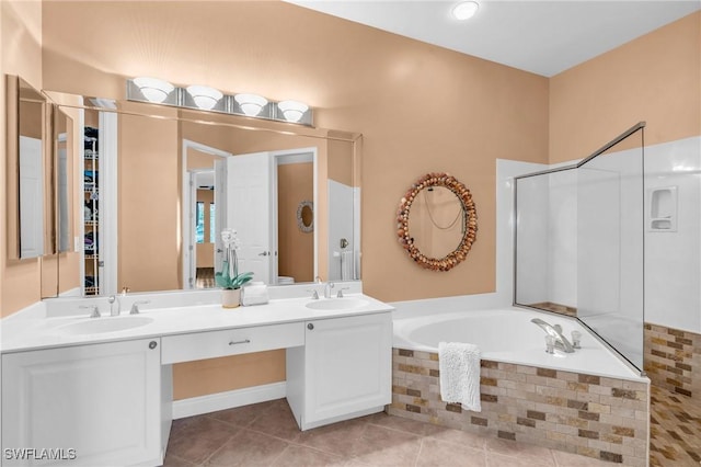 bathroom with vanity, tiled bath, and tile patterned flooring