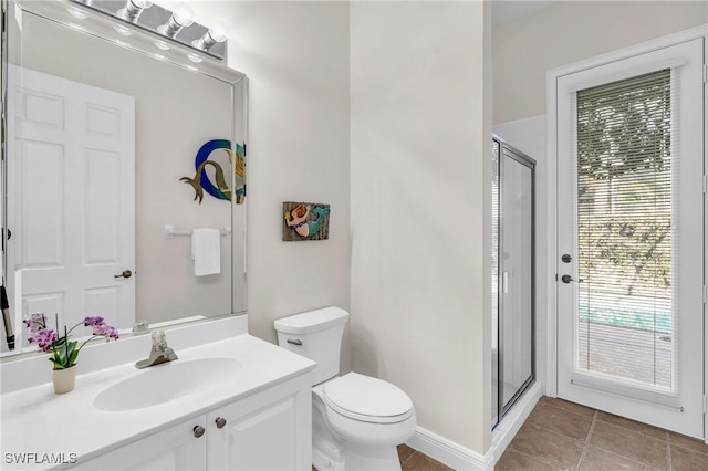 bathroom featuring vanity, tile patterned floors, a shower with door, and toilet