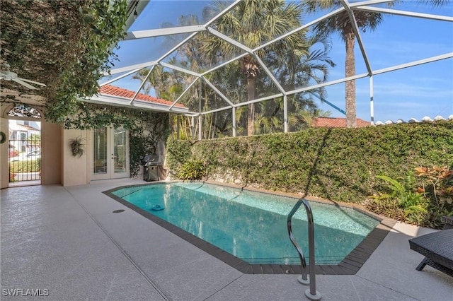 view of swimming pool with french doors, a lanai, and a patio area