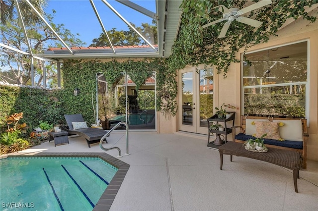 view of swimming pool featuring french doors, ceiling fan, a lanai, and a patio area