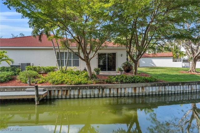 rear view of property with a yard and a water view