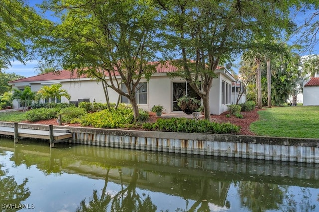 back of property featuring a water view and a yard