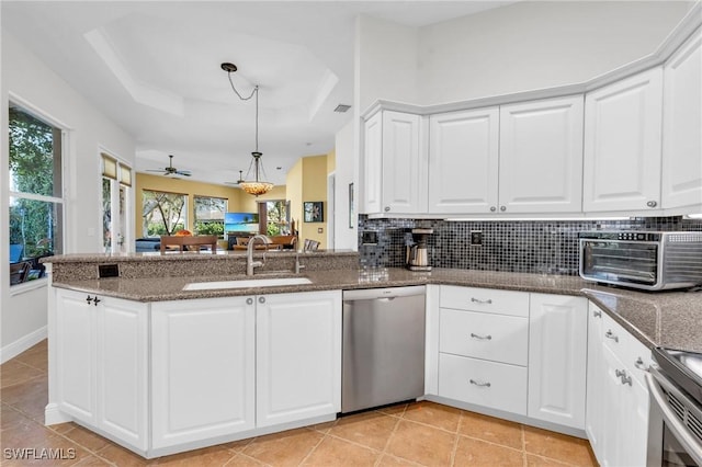 kitchen featuring white cabinetry, stainless steel appliances, a tray ceiling, and sink