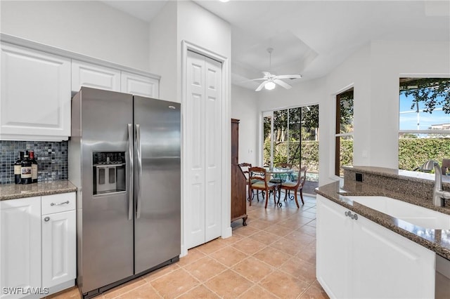 kitchen featuring sink, white cabinetry, dark stone countertops, tasteful backsplash, and stainless steel fridge with ice dispenser