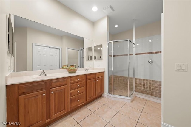 bathroom with an enclosed shower, vanity, and tile patterned floors