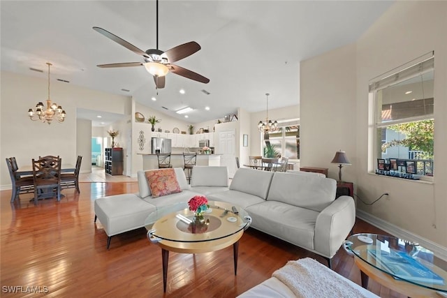 living room with lofted ceiling, dark hardwood / wood-style floors, and ceiling fan with notable chandelier