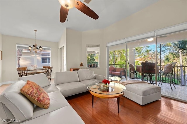 living room with hardwood / wood-style flooring and ceiling fan with notable chandelier