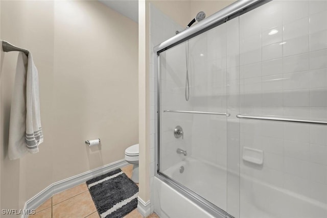 bathroom with bath / shower combo with glass door, tile patterned floors, and toilet