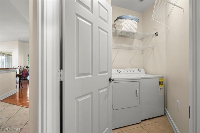 laundry room featuring washer and dryer and light tile patterned floors