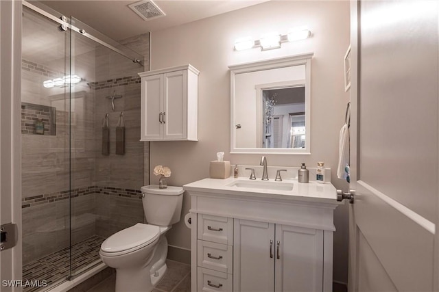 bathroom featuring vanity, a shower with shower door, and toilet