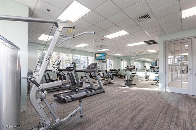 gym featuring carpet flooring, a drop ceiling, and french doors