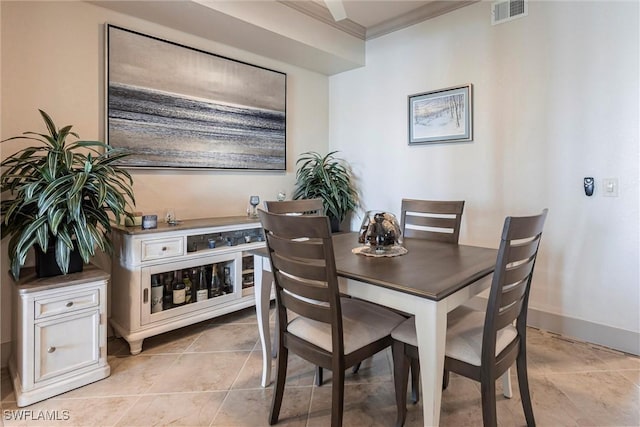 dining space featuring light tile patterned flooring and ornamental molding