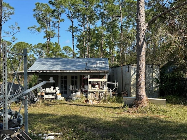 back of house featuring an outbuilding and a yard