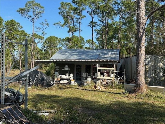 rear view of property featuring an outbuilding and a lawn