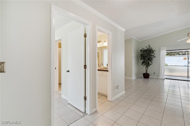 hall featuring light tile patterned flooring, ornamental molding, a textured ceiling, and a baseboard radiator