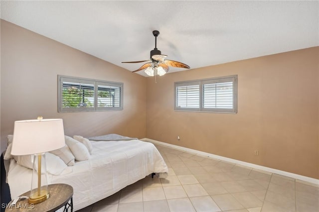 tiled bedroom featuring multiple windows, lofted ceiling, and ceiling fan