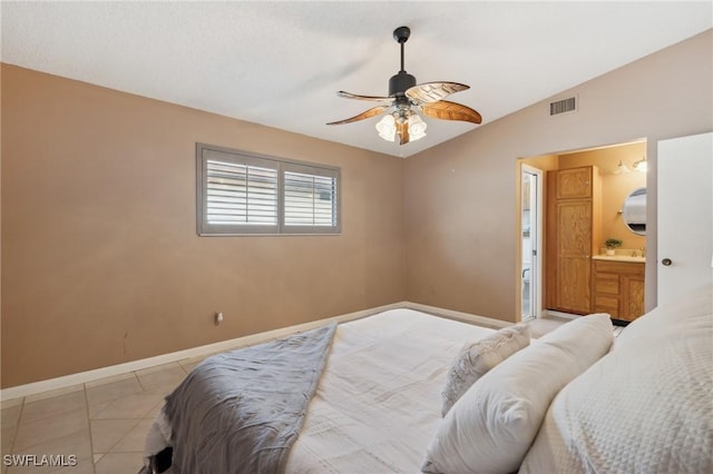 tiled bedroom with ceiling fan, lofted ceiling, and ensuite bathroom