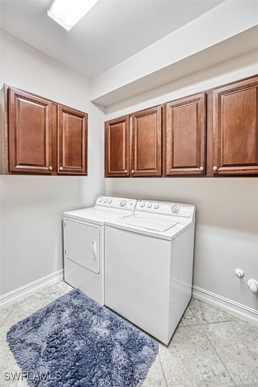 laundry room with washing machine and clothes dryer, cabinet space, and baseboards