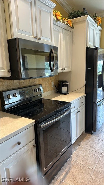 kitchen featuring stainless steel appliances, white cabinetry, light countertops, ornamental molding, and backsplash