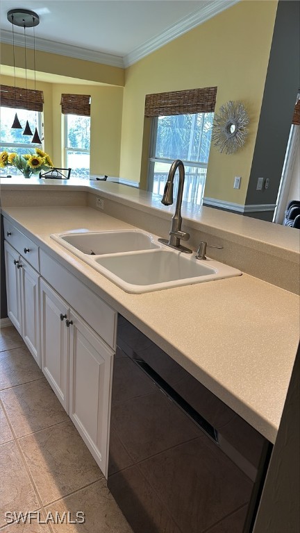 kitchen with crown molding, a sink, white cabinetry, black dishwasher, and pendant lighting