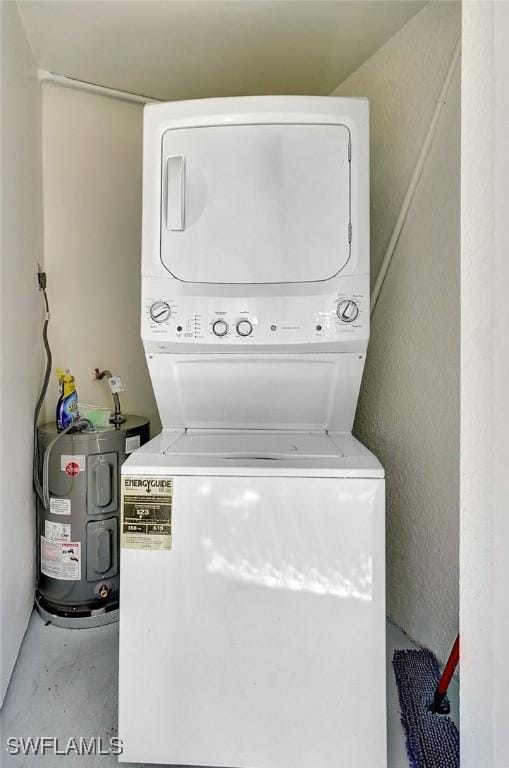 laundry area with laundry area, water heater, and stacked washer / drying machine