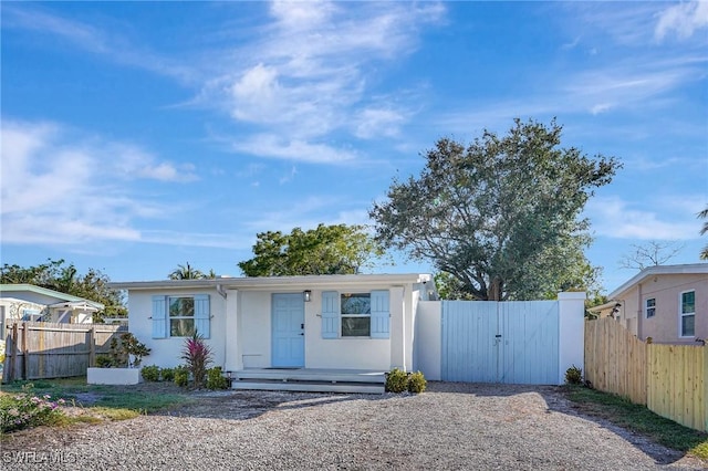 view of front of house featuring a gate, fence, and stucco siding