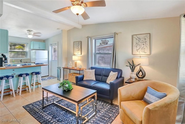 living area featuring a ceiling fan, a healthy amount of sunlight, lofted ceiling with beams, and light tile patterned floors