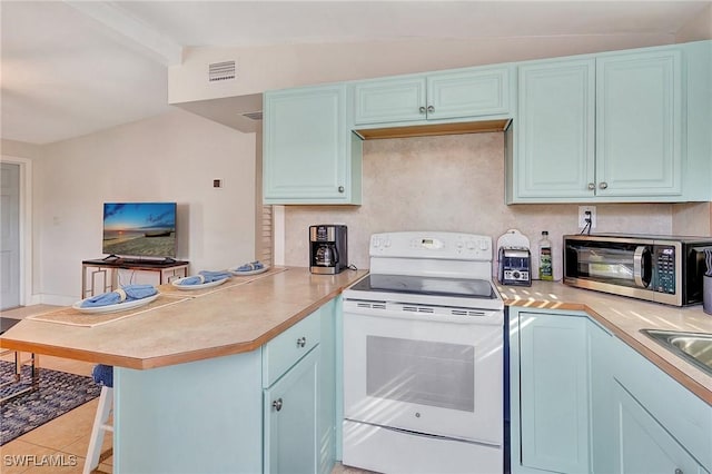 kitchen featuring electric stove, stainless steel microwave, a peninsula, and blue cabinets