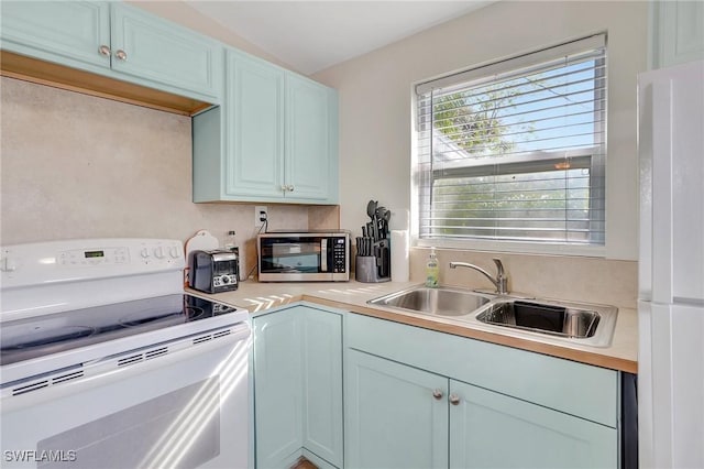 kitchen with light countertops, white appliances, and a sink