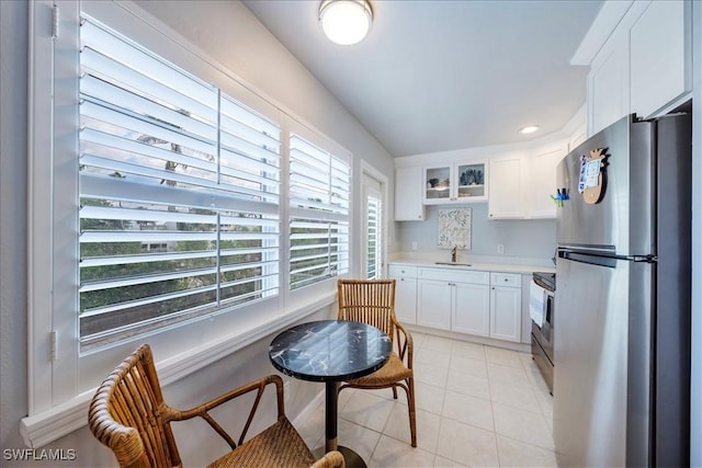 kitchen featuring white cabinetry, sink, light tile patterned floors, and stainless steel appliances