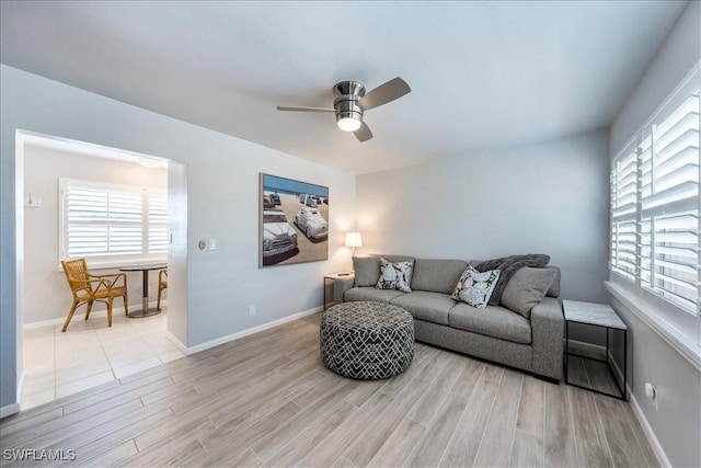 living room with light hardwood / wood-style flooring, plenty of natural light, and ceiling fan