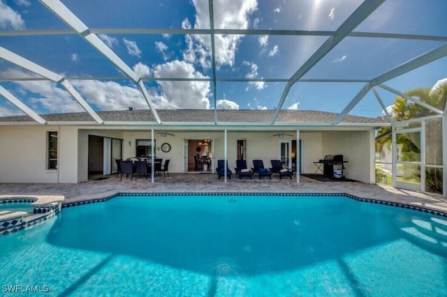 view of swimming pool with an in ground hot tub, a lanai, and ceiling fan