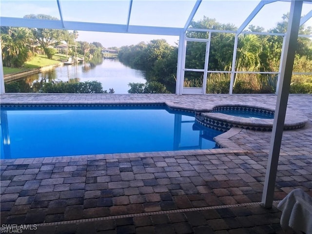 view of swimming pool featuring an in ground hot tub, a water view, a lanai, and a patio