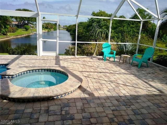 view of swimming pool featuring an in ground hot tub, a water view, glass enclosure, and a patio