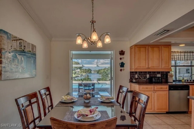 dining space with ornamental molding, light tile patterned floors, and an inviting chandelier