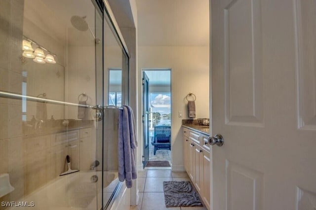 bathroom with tile patterned floors, vanity, and combined bath / shower with glass door