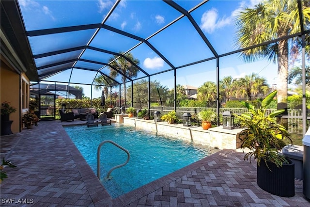 view of swimming pool featuring outdoor lounge area, pool water feature, a lanai, and a patio area