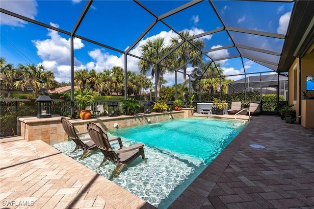 view of pool with a hot tub, a patio, a lanai, and pool water feature