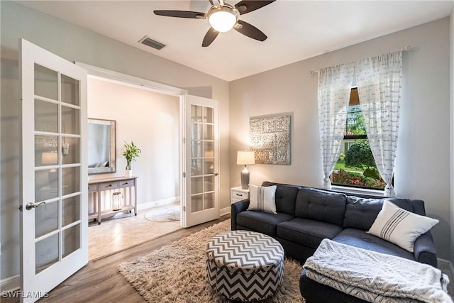 living room with french doors, ceiling fan, and light hardwood / wood-style floors