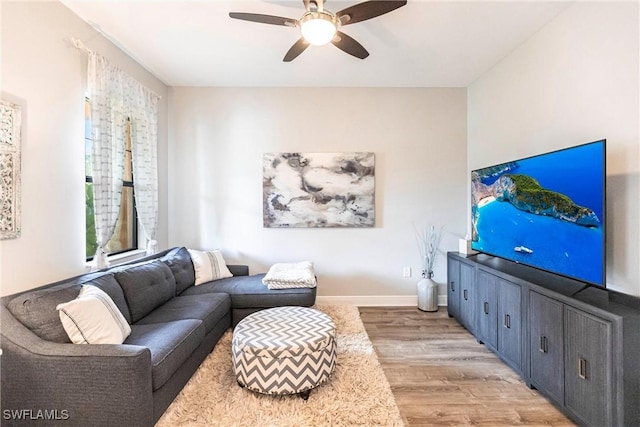 living room featuring light hardwood / wood-style flooring and ceiling fan