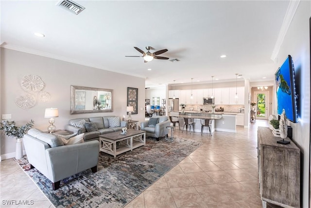 tiled living room with crown molding and ceiling fan